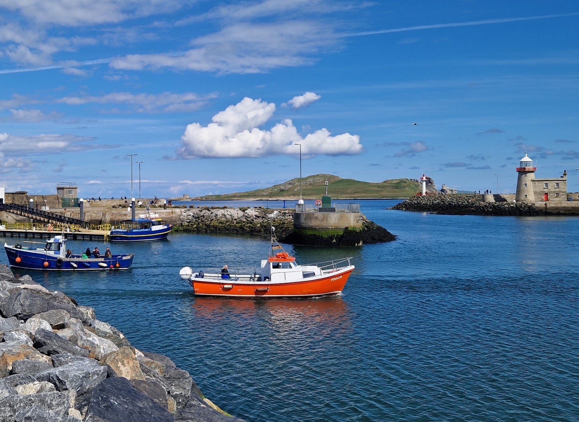 A small ferry boat departing a harbour