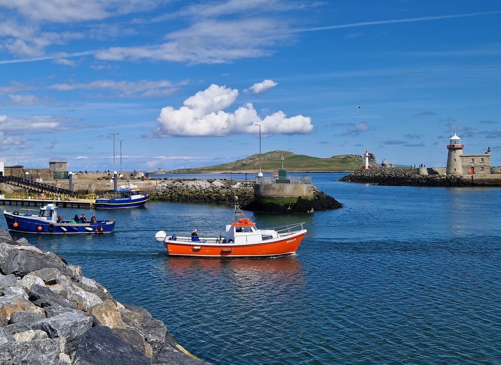 A small ferry boat departing a harbour