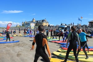 Group in the beach standing on surf boards