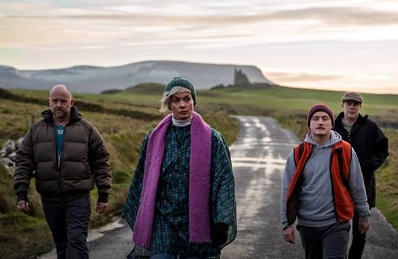4 adults walking along a country lane on a dull day.