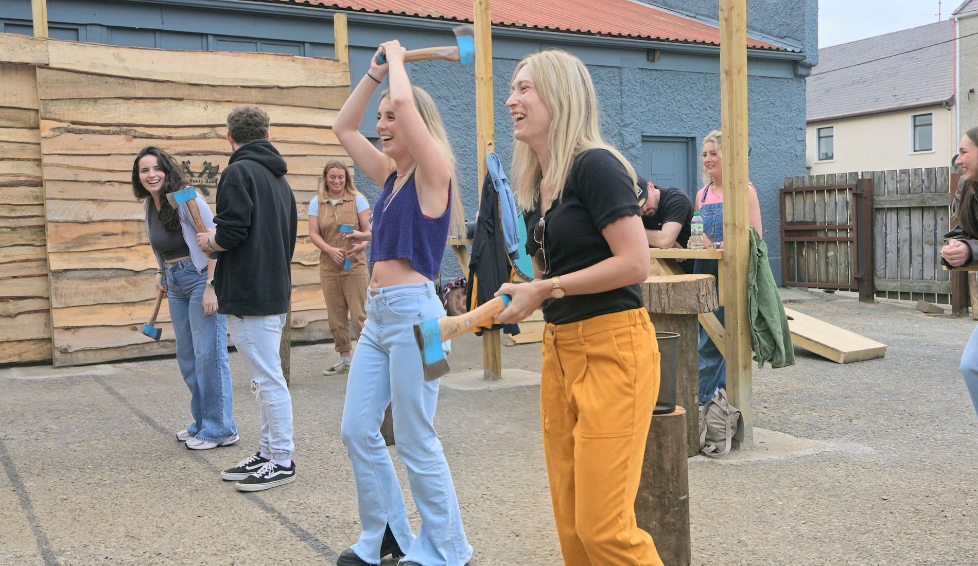 Group participating in outdoor axe throwing session with instructors