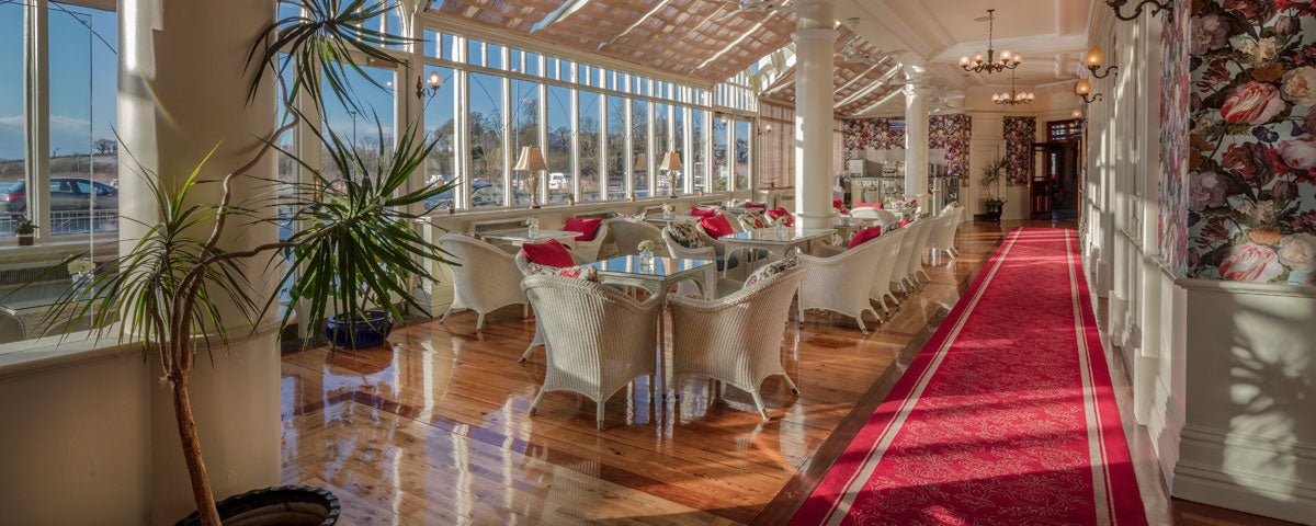 A row of tables and chairs along  a line of windows at the Aroma Café