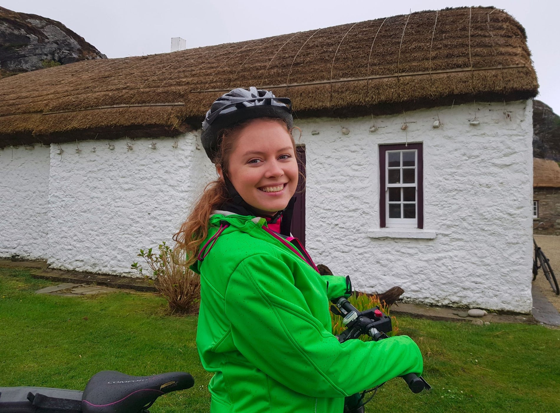 Lady stands with her electric bicycle at Glencolmcille Folk Village Experience with Ireland By Bike