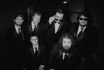 Ole 60, black and white photo of 6 men in dark suits and ties.