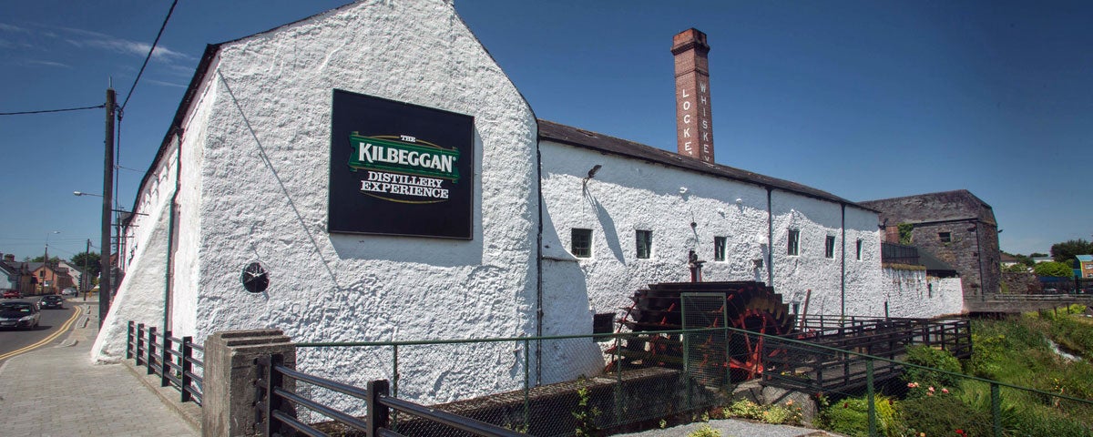 The exterior of the Kilbeggan Distillery Experience building with the old chimney in the background