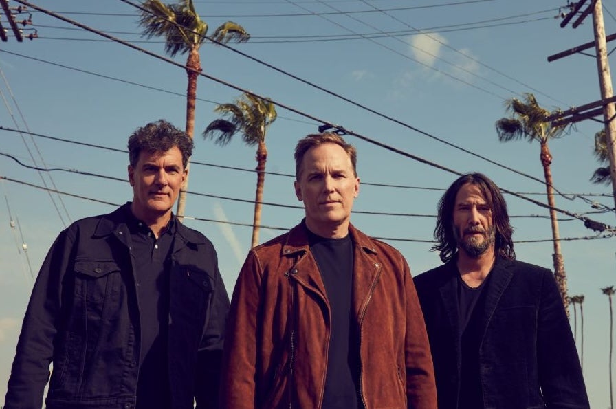 American alternative rock outfit Dogstar, 3 men outdoors with tall palm trees in the background.