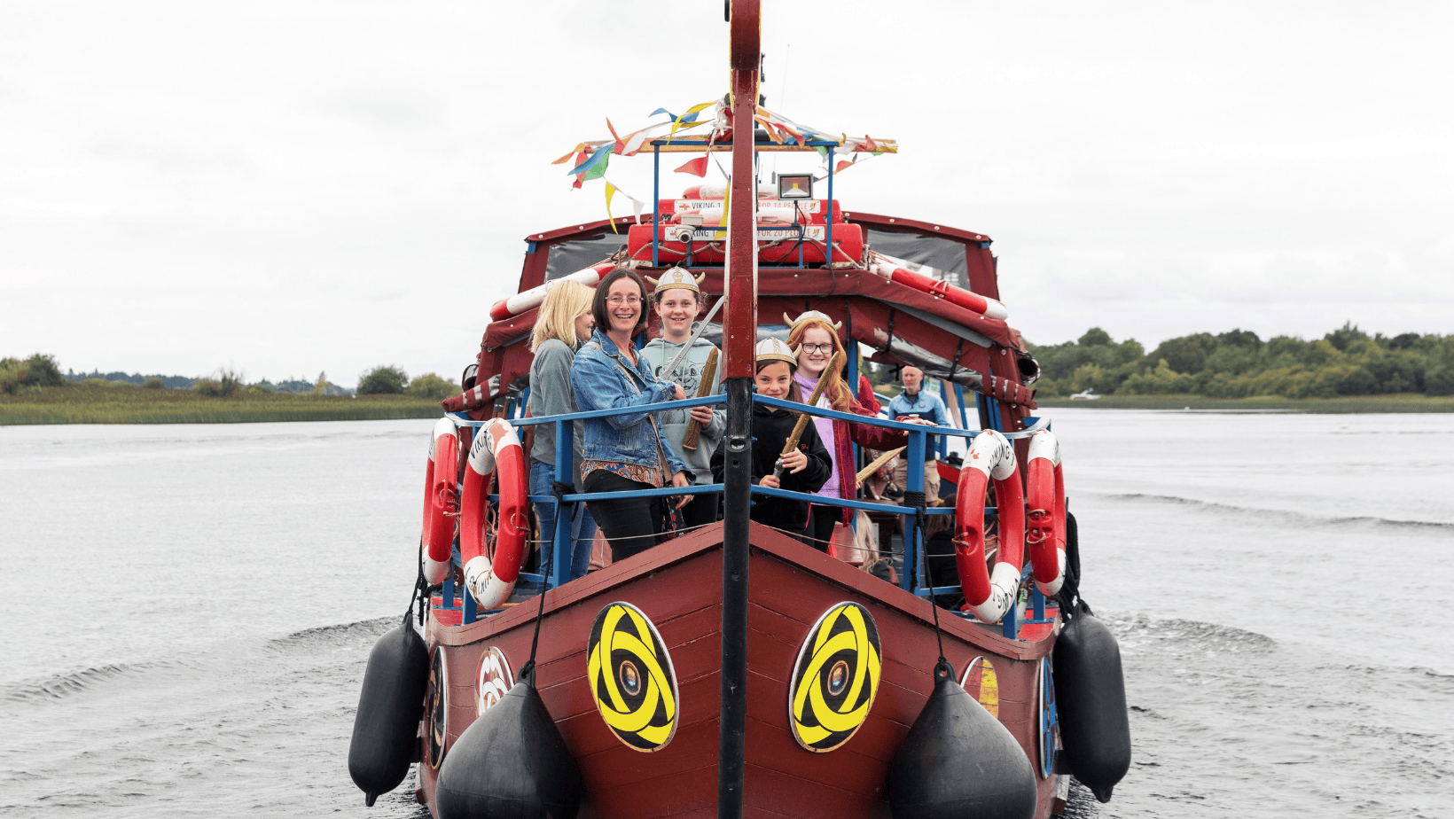 Viking Tours Cruise in Athlone, Co.Westmeath - small brown boat on a wide body of water with people standing around the front of boat.