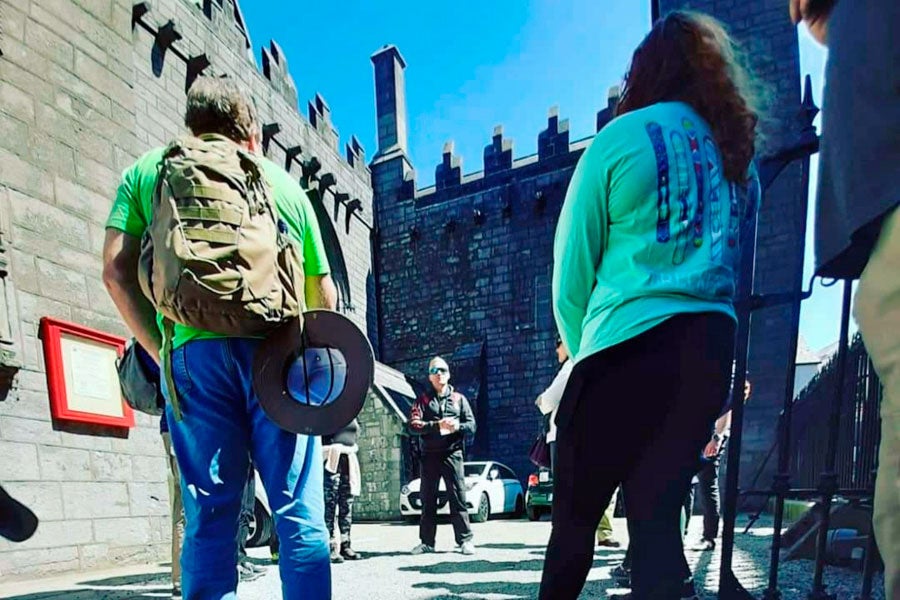 A small group of people on a guided walking tour of Galway City with the guide standing in the background