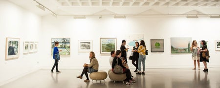 People sitting and people standing in a spacious gallery