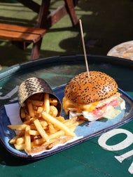 A burger with a sesame seed bun and side chips form the menu at The Bloody Stream