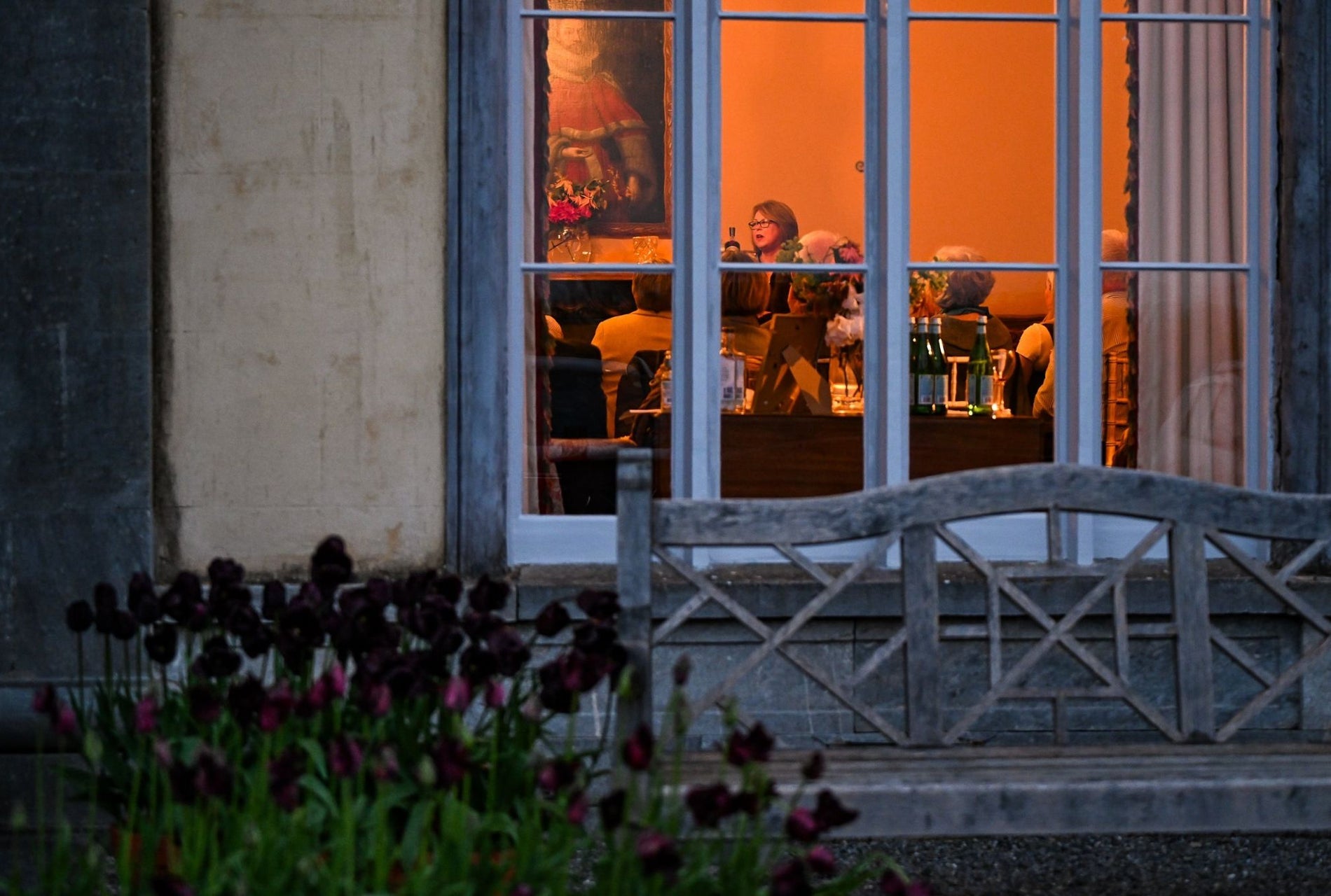 View through a window to a group of people at a story telling evening