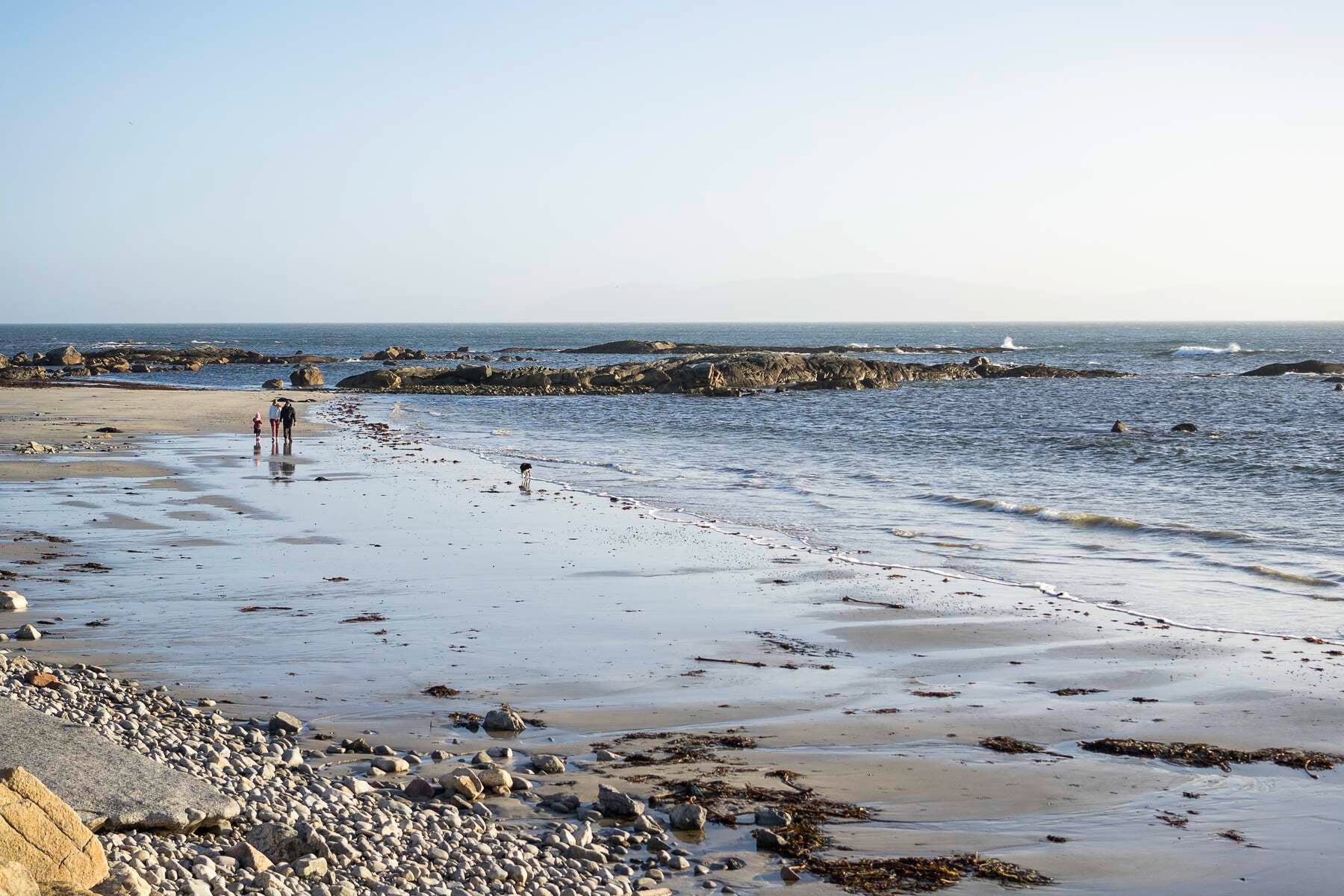 Stone and sand beach with people walking