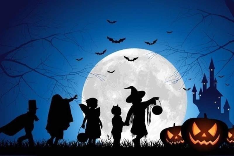 Children trick or treating in the moonlight on Halloween.