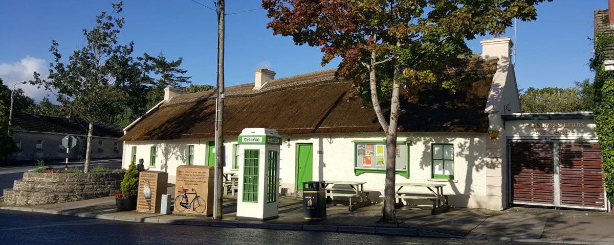 A white washed traditional cottage with a thatched roof