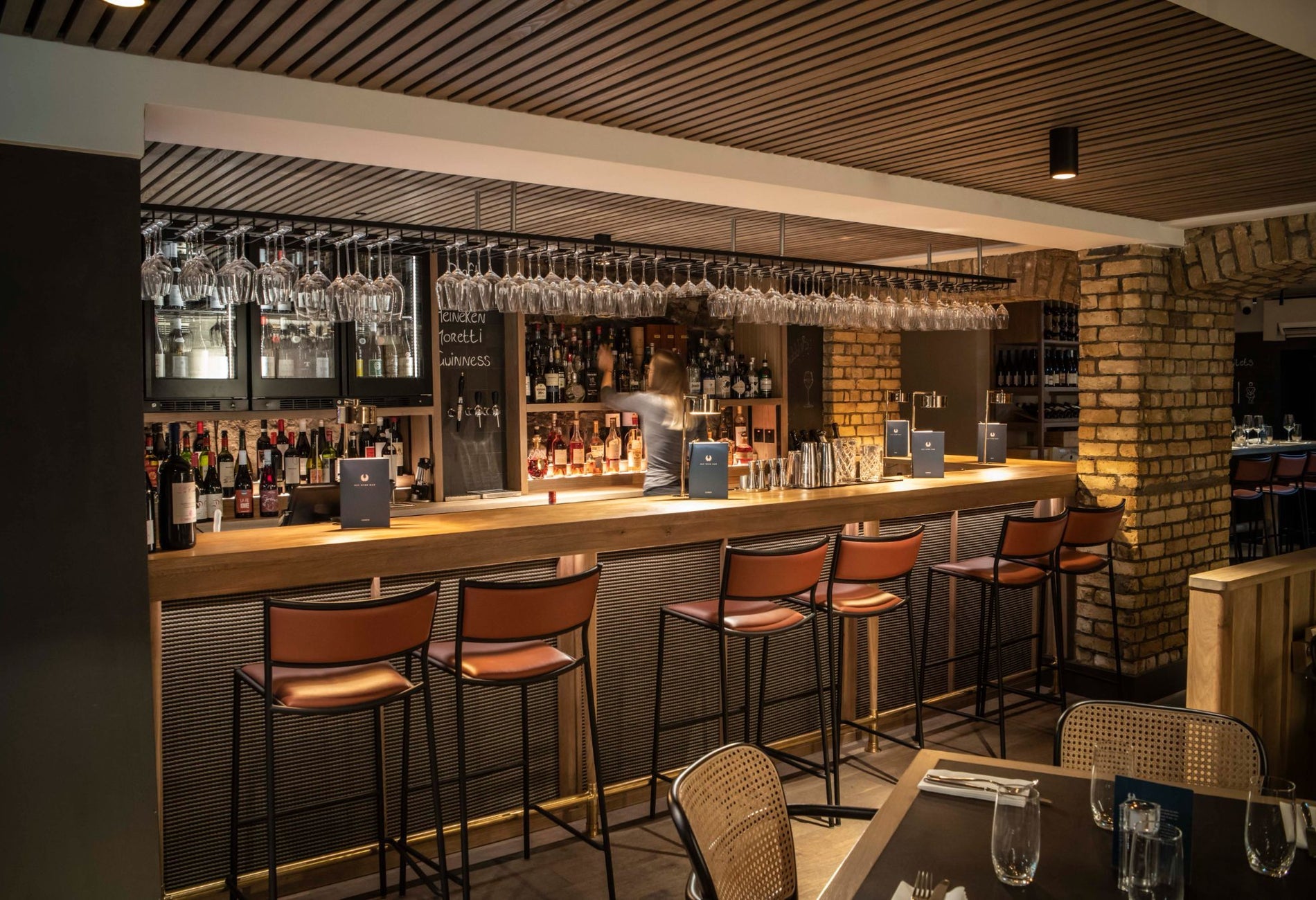 Interior of a bar with a counter six high stools and a table set for service