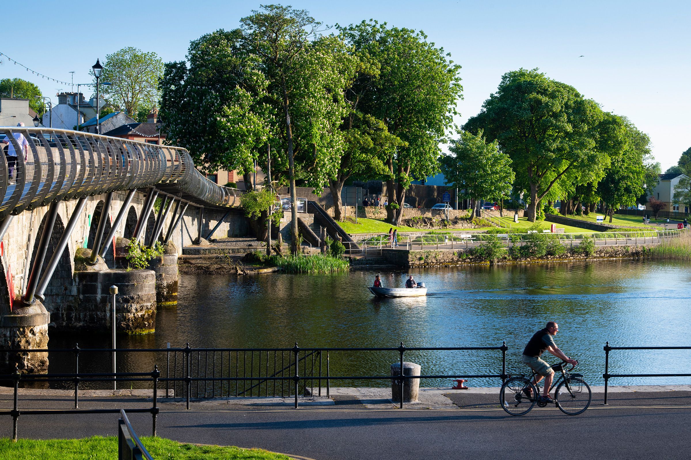 A cyclist on a sunny day cycling beside the River Shannon in County Leitrim 