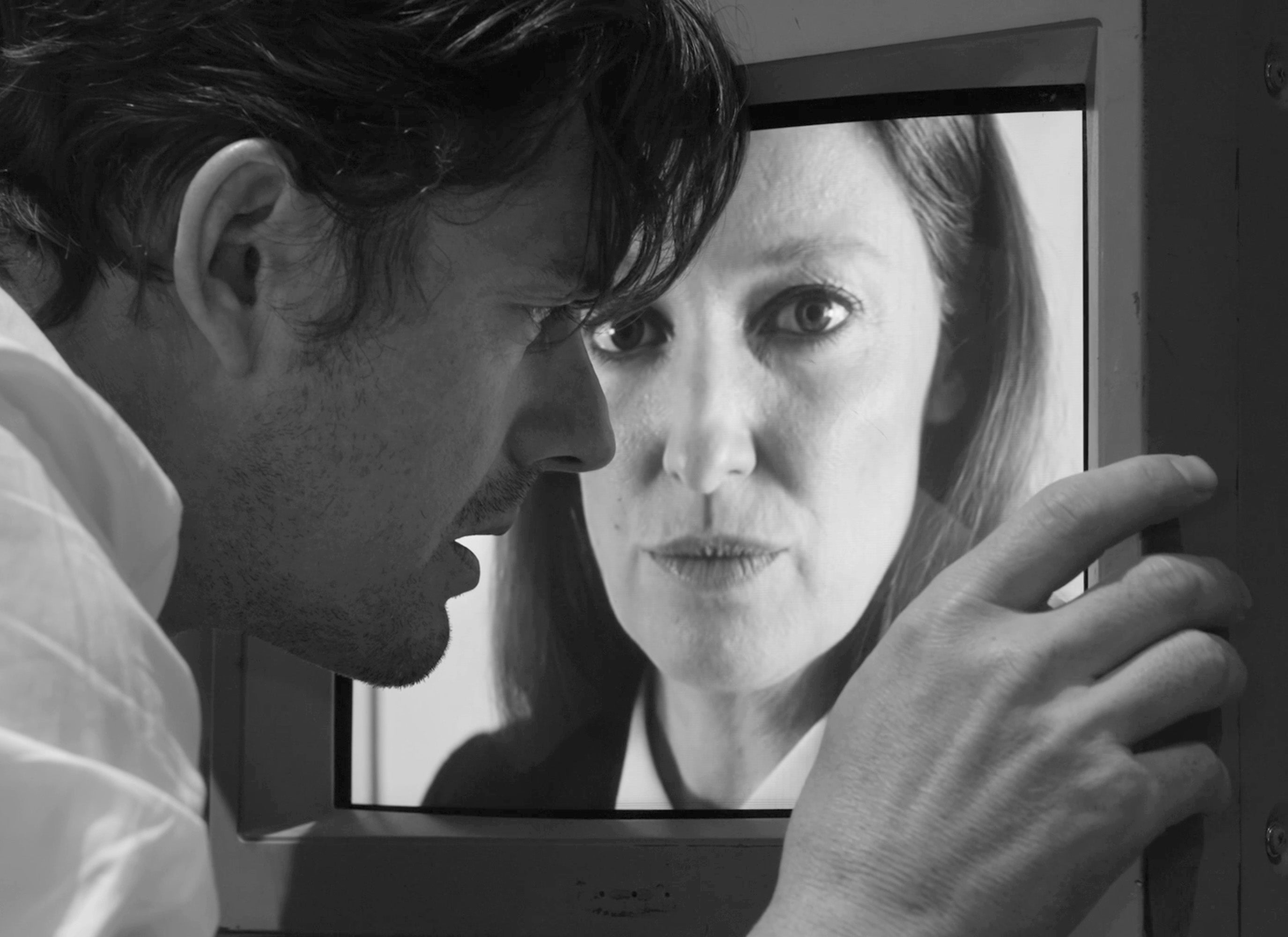 A man is looking closely at an image of a woman's face.