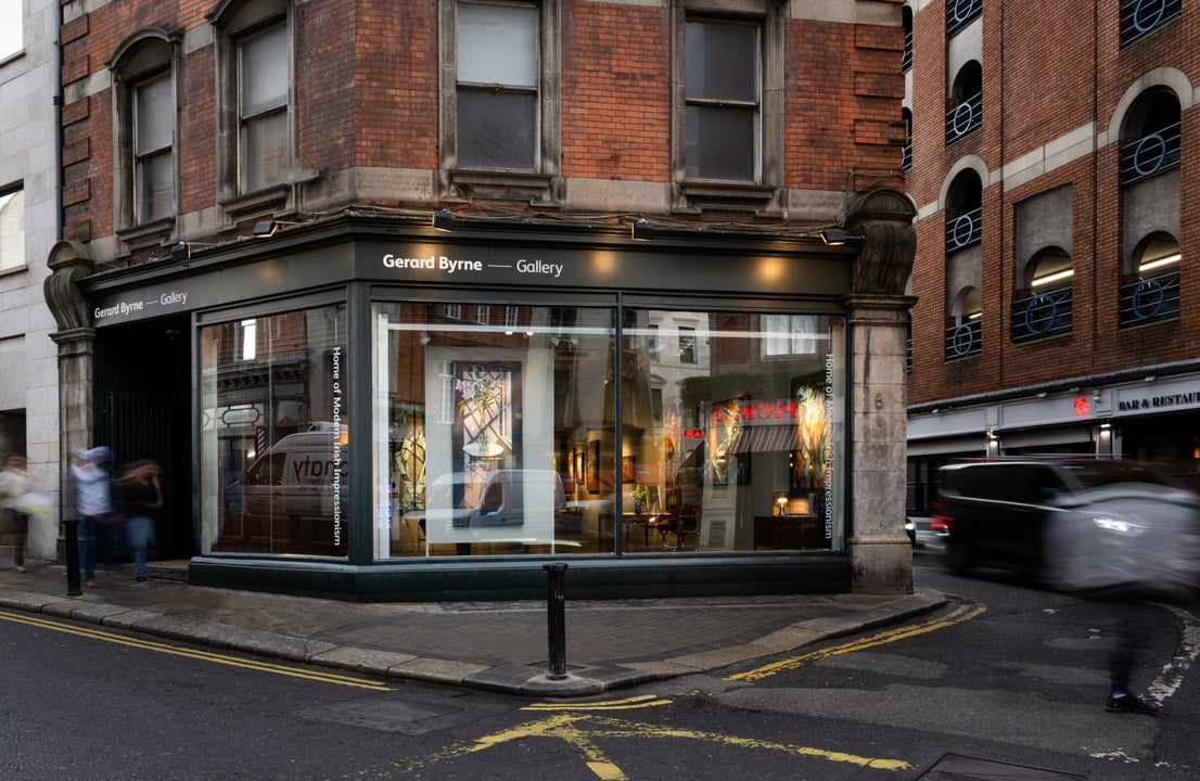The exterior of a gallery with a black shopfront on a red brick building