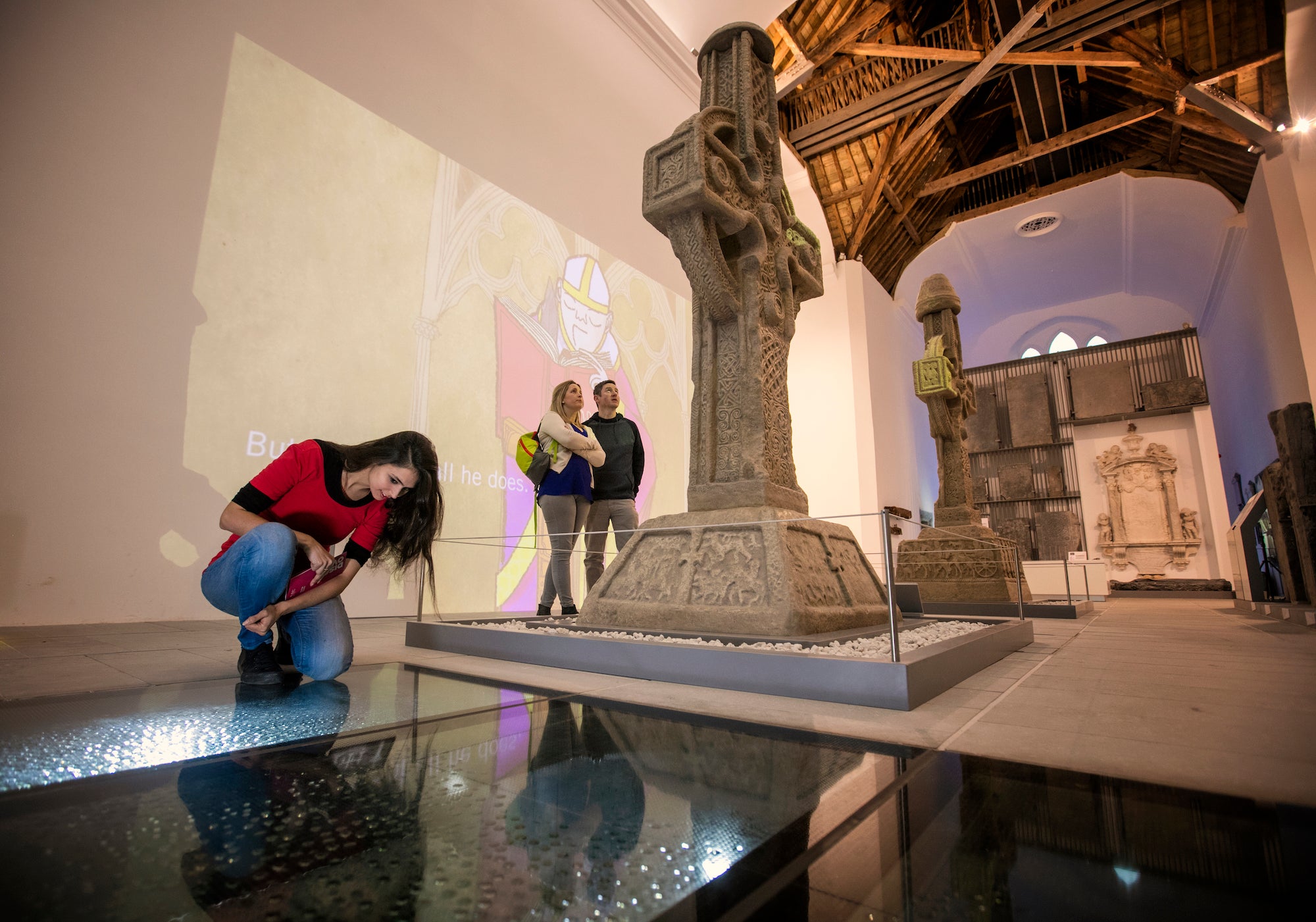 Three people observing the religious relics on display at the Medieval Mile Museum in County Kilkenny.