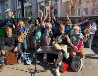 A group of people having fun with instruments on a Songwriter Tour