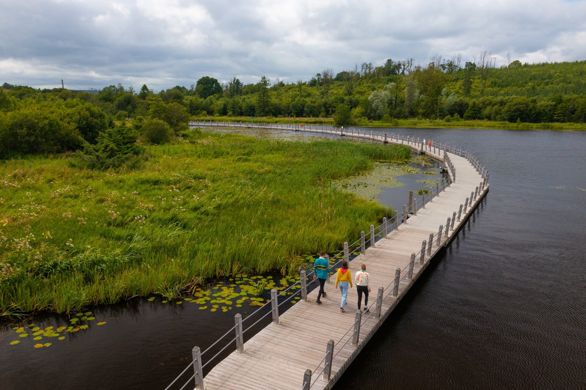 People walking the Acres Lake Floating Boardwalk in Co Leitrim