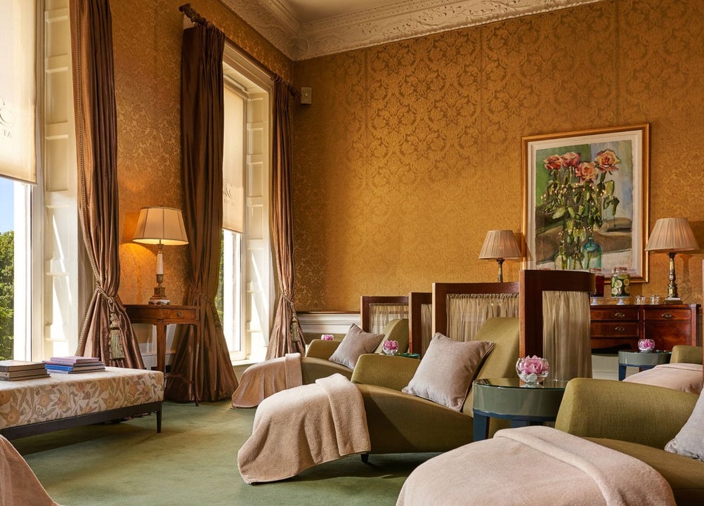 Three spa beds with blankets and cushions in a relaxation room