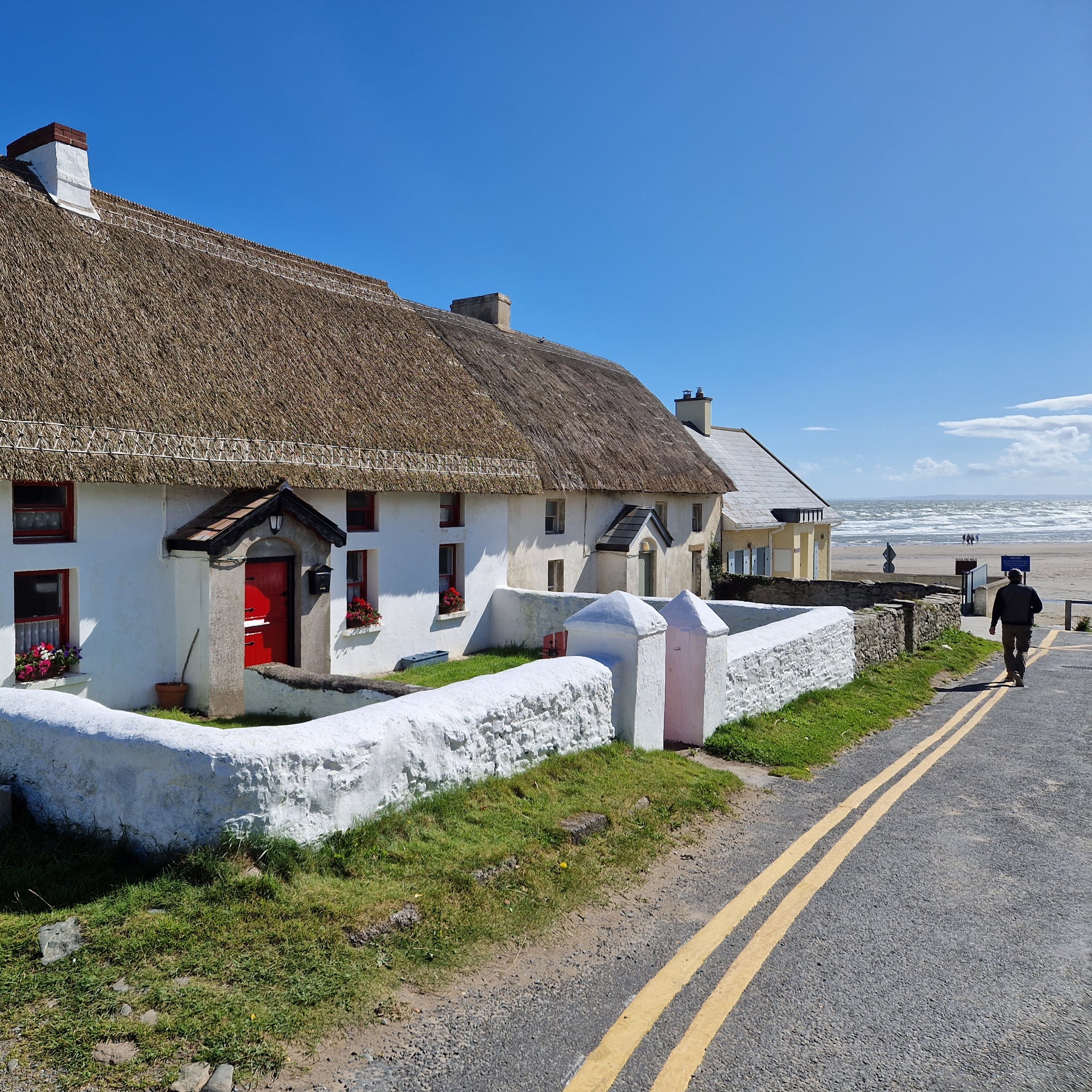 A pair of traditional thatched cottages and views of Clogherhead beach in County Louth