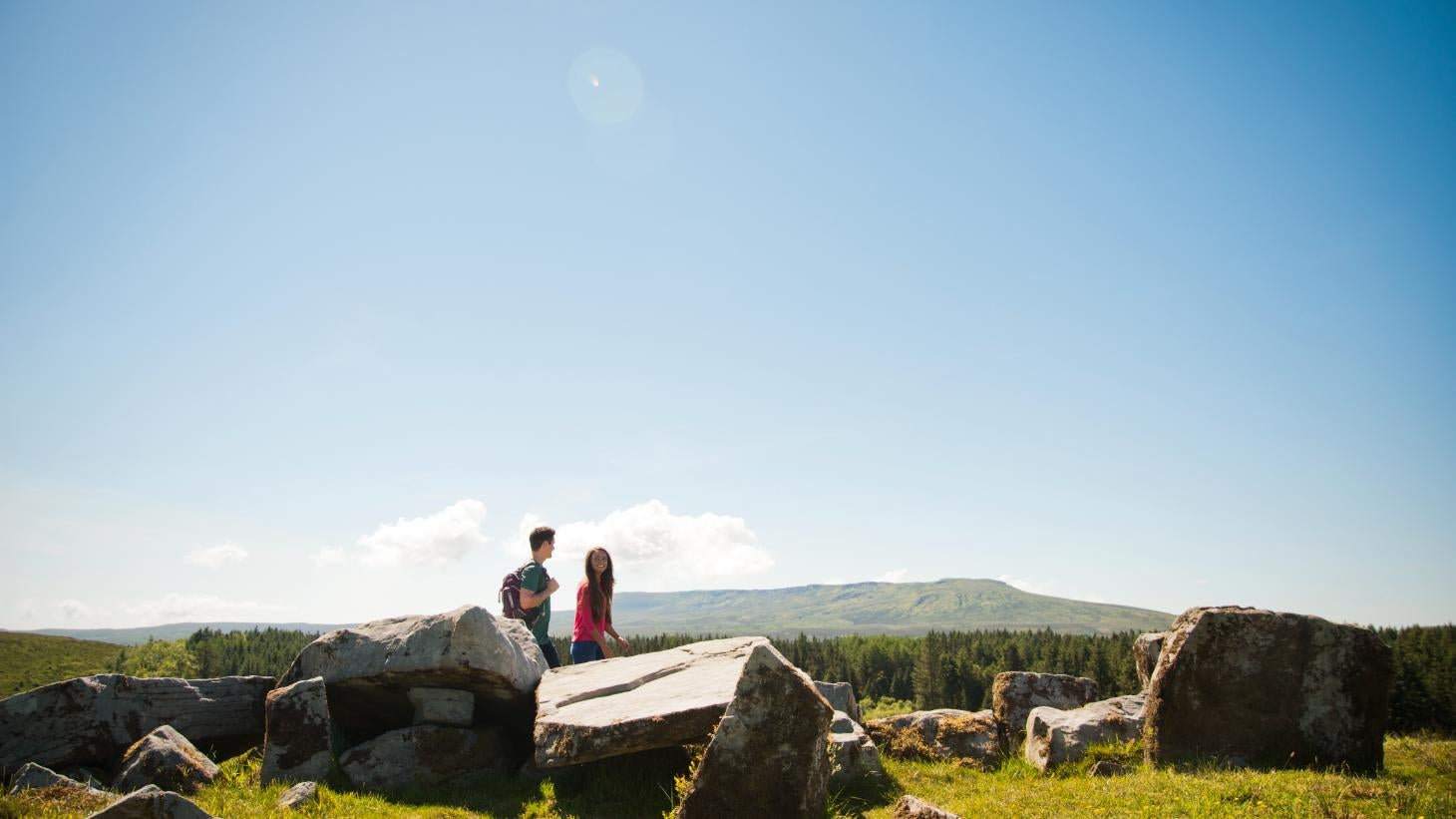 Man and woman walking through Cavan Burren Park on a sunny day