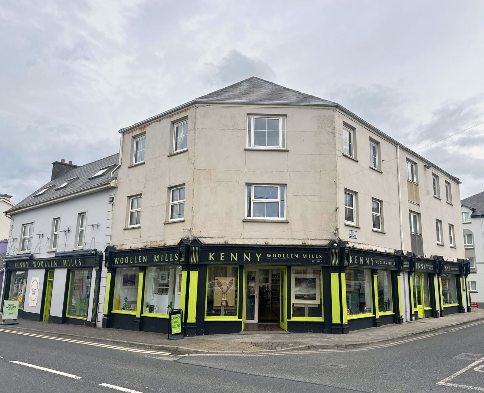 Black and yellow painted shop front with and windows and an open door