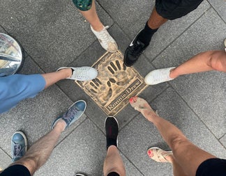 People point to the Ronnie Drew plaque with their feet on a Dublin City street