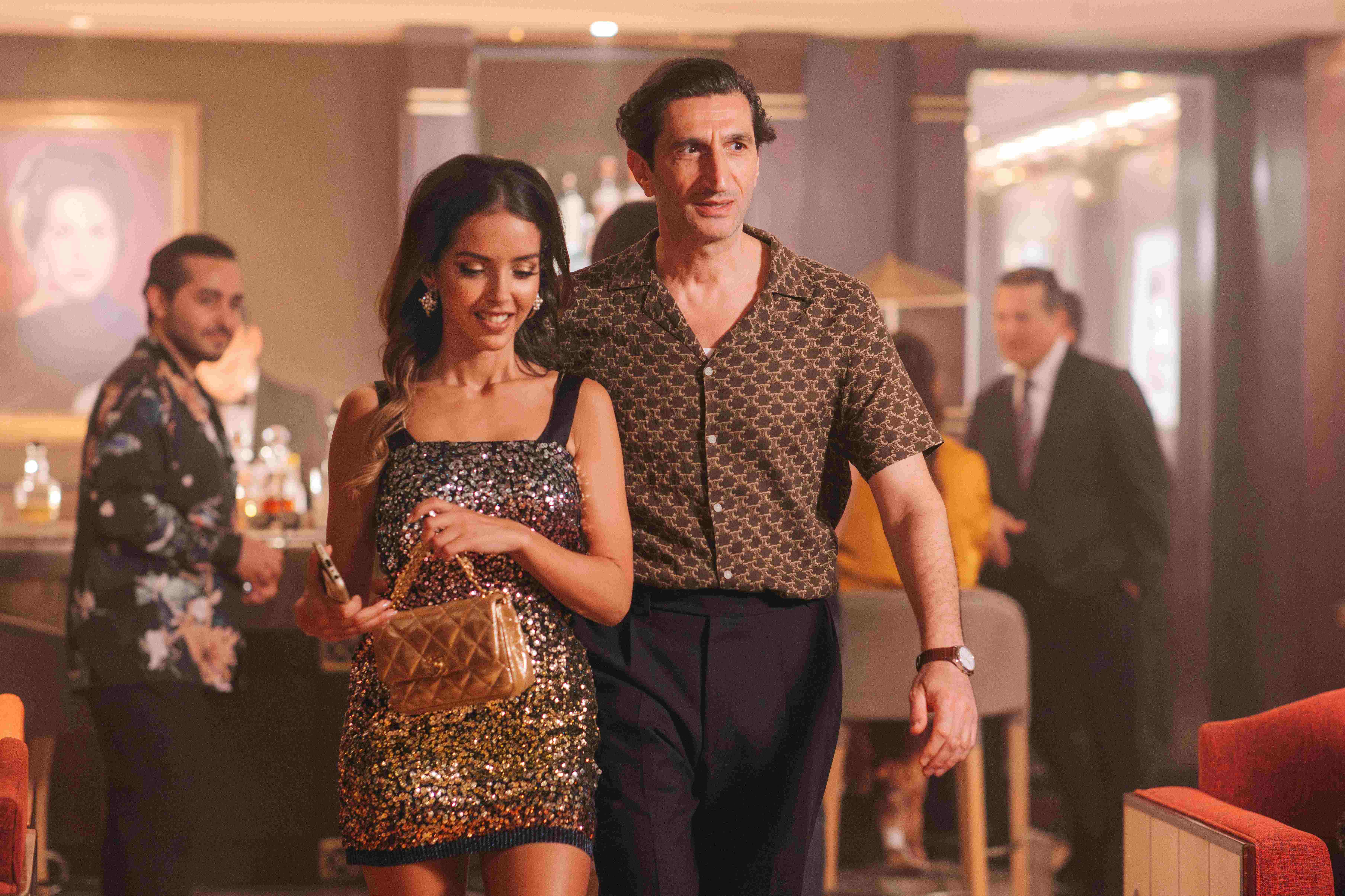 A man with his arm around a woman's waist. He seems slightly nervous.