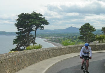 Irish Cycling Safaris cyclist on Killiney Hill with a view of the Dublin Mountains and the sea