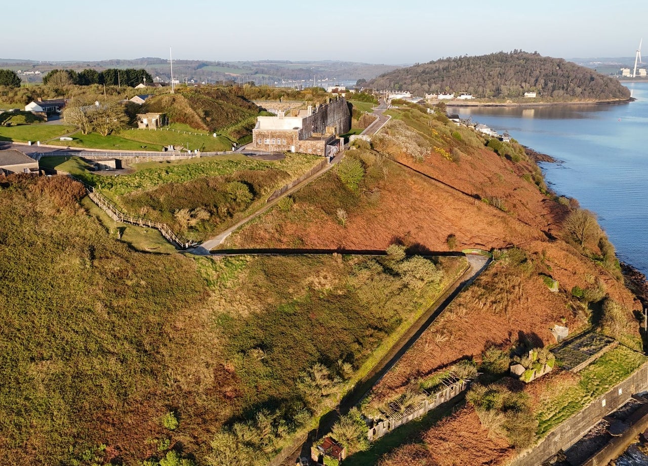 Aerial view of fort with a walking path running down to the coast