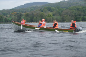 A Shannon Boat Hire lake boat on the water with paddling passengers