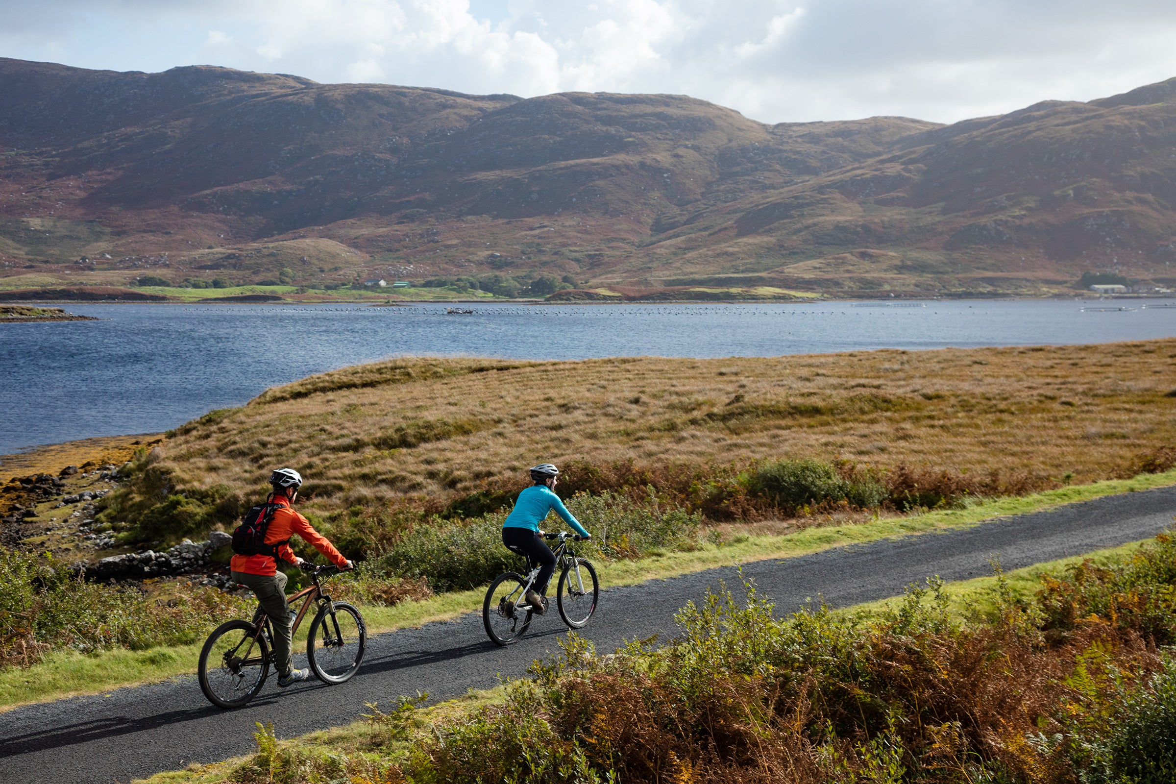 Cyclists by the water on a sunny day