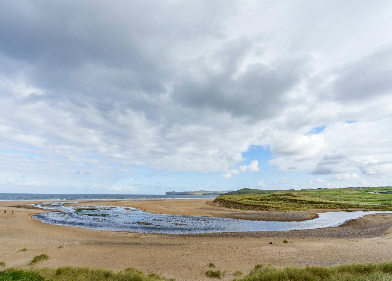 A sandy beach with an inlet of water in the middle