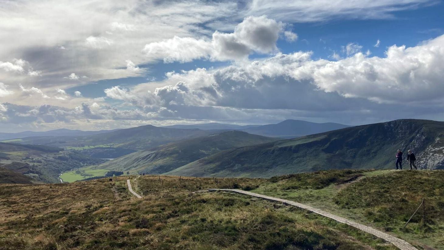 Two walkers on the Wicklow Way overlooking the Wicklow National Park.