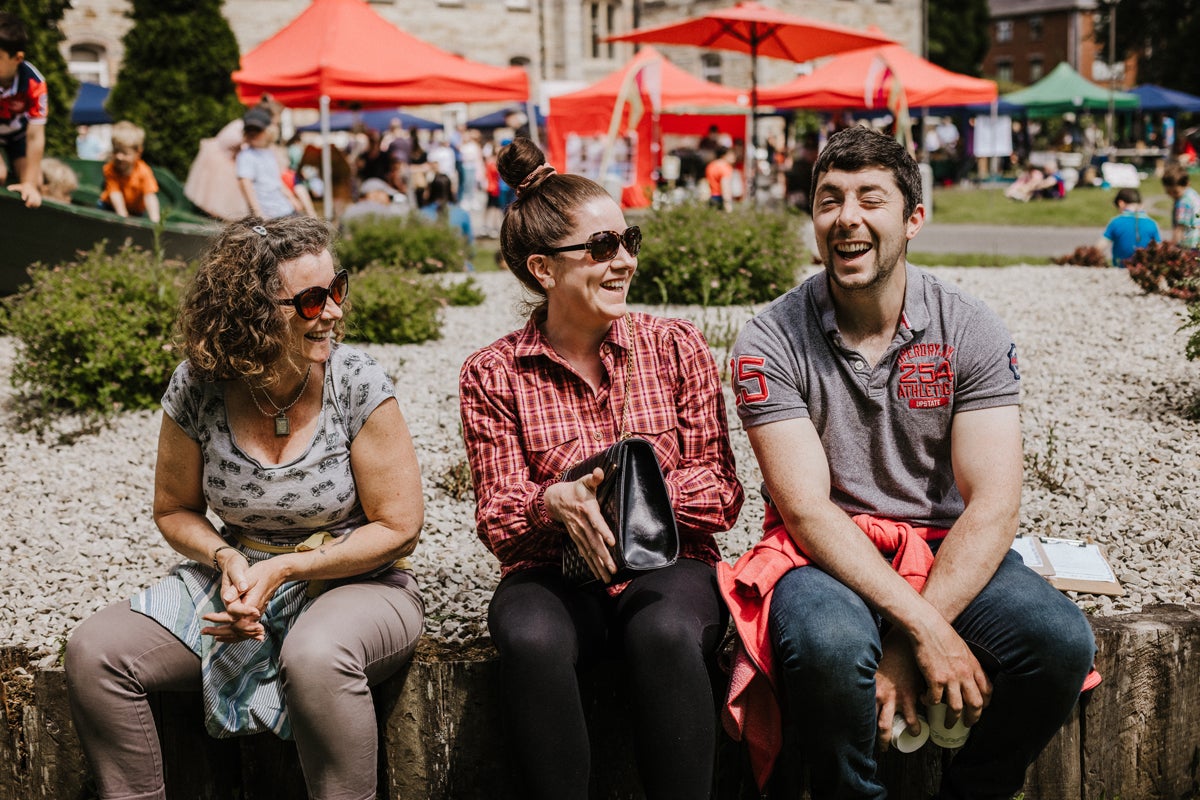 Visitors laughing and enjoying the outdoor market atmosphere.