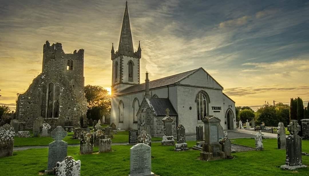 Graveyard in front of a church style building at sunset