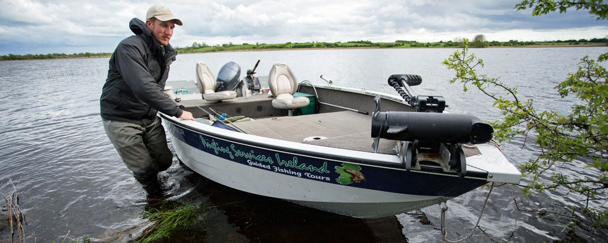A man in the water bringing his boat ashore