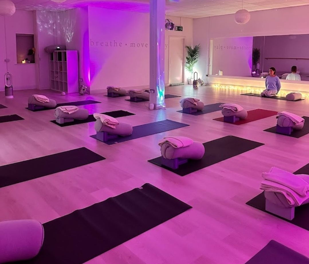 Studio set up for a yoga class with mats and blankets