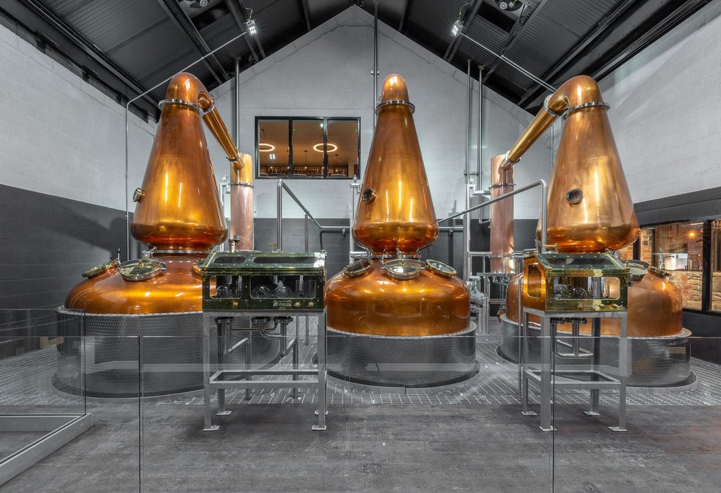 Three large copper stills in a distillery