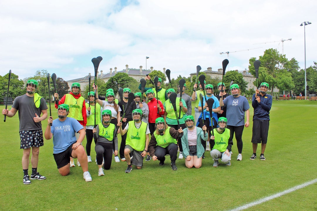 Experience Gaelic Games group in a field with hurleys