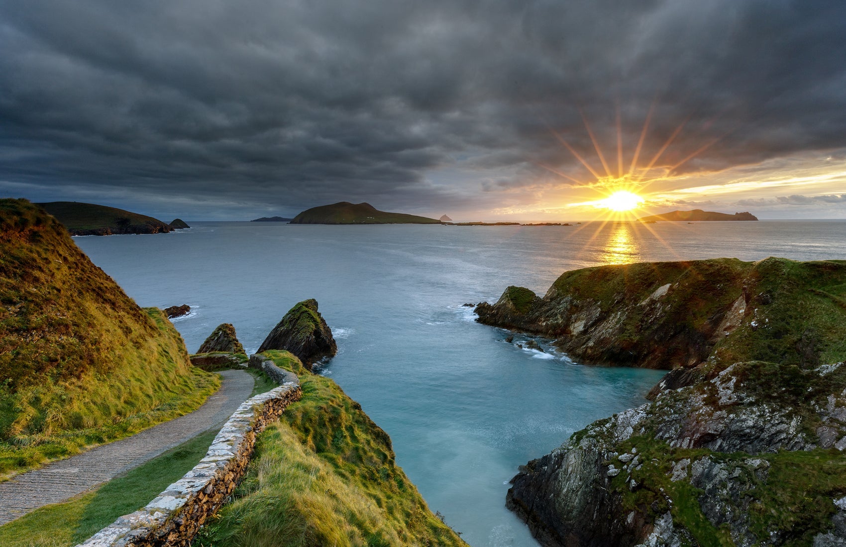 A winding road with coastal view as the sun goes down