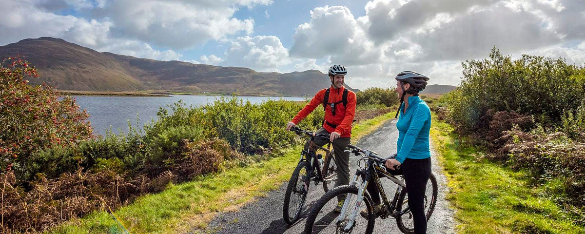 Clew Bay Bike Trail with two cyclists next to the bay and mountains