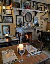 Interior of a traditional Irish pub with tables set for dinner by an open fire