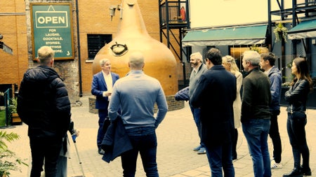 A group stand by whiskey stills on a tour