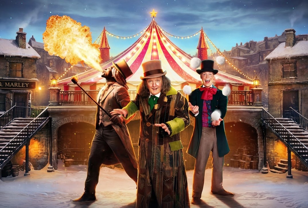 Scrooge: A Cirque Spectacular at Gleneagle, 3 performers in different costumes with hats, with roof of circus tent behind in winter with snow on the ground.