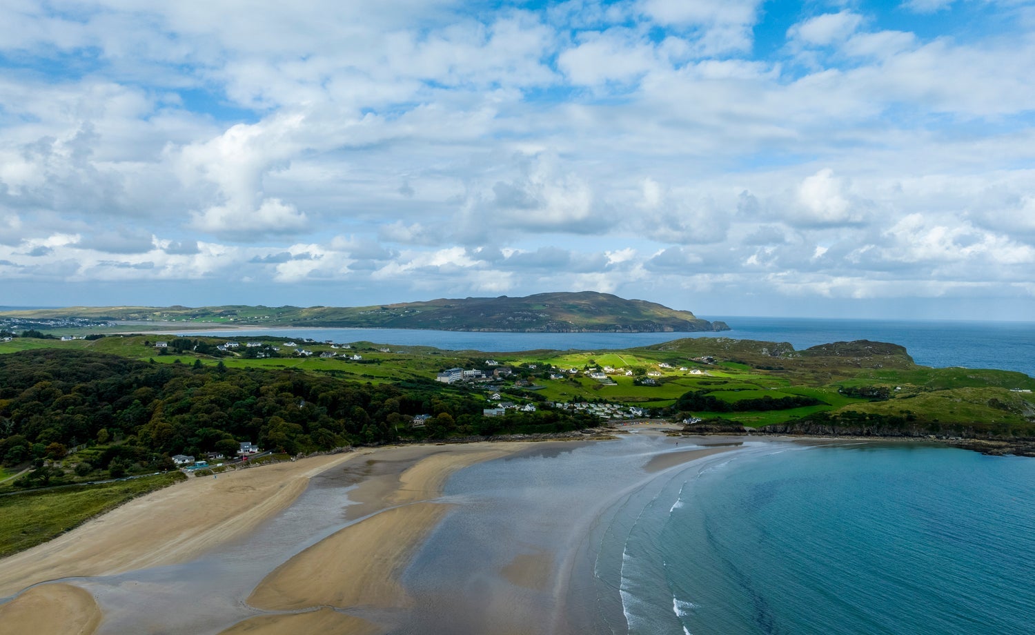 An aerial view of a beach with the tide going out