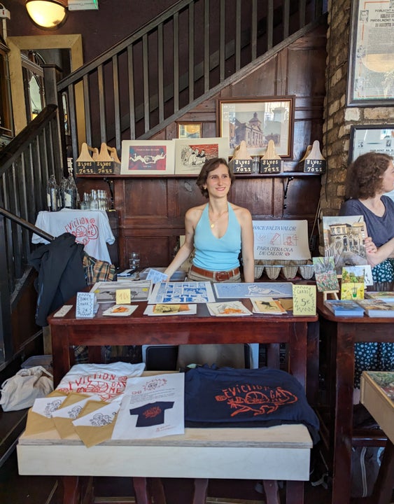 A lady standing at her stall selling t-shirts
